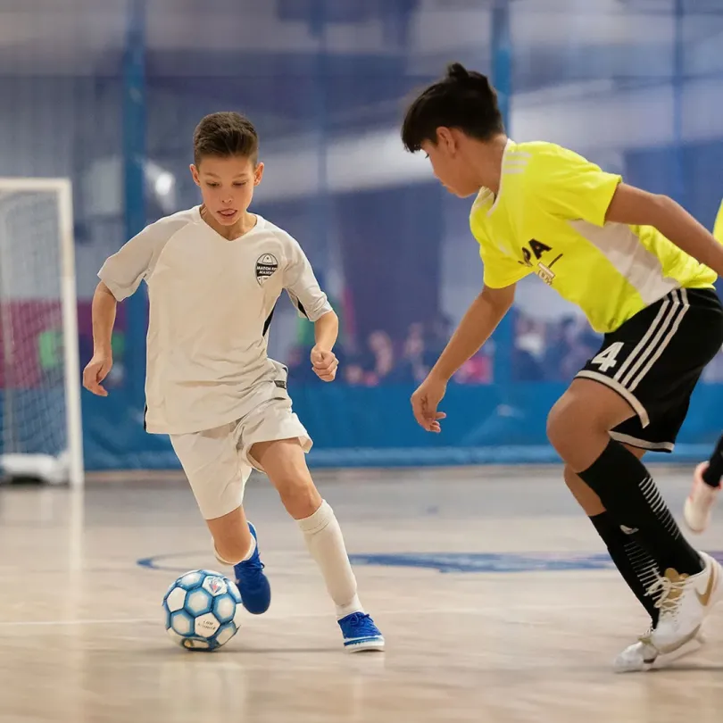 Two boys play a game of futsal.