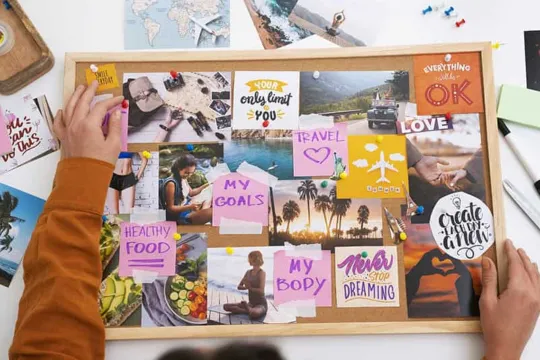 Overhead view of a person working on a vision board.