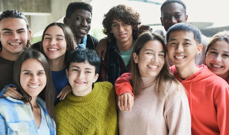 A group of teens smile at the camera.