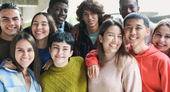 A group of teens smile at the camera.