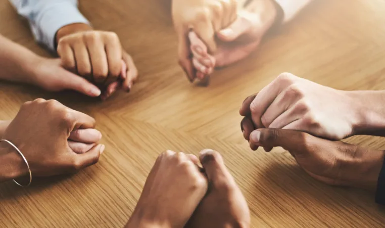 A group of people hold hands.