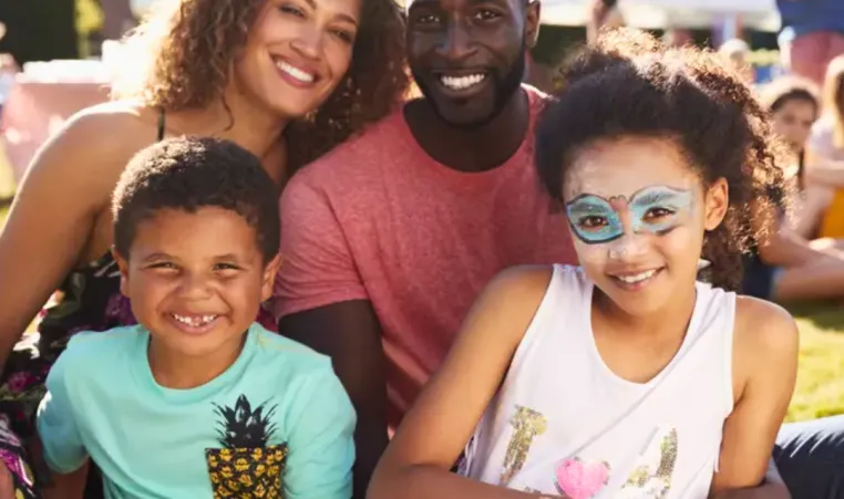 A family of four smile and have fun at a family festival.